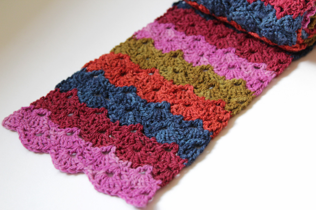 Don't let your favorite scraps go to waste! Crochet the free Scrap Scallops Scarf to elegantly showcase your favorite yarns. Visit handsoccupied.com for the free pattern.